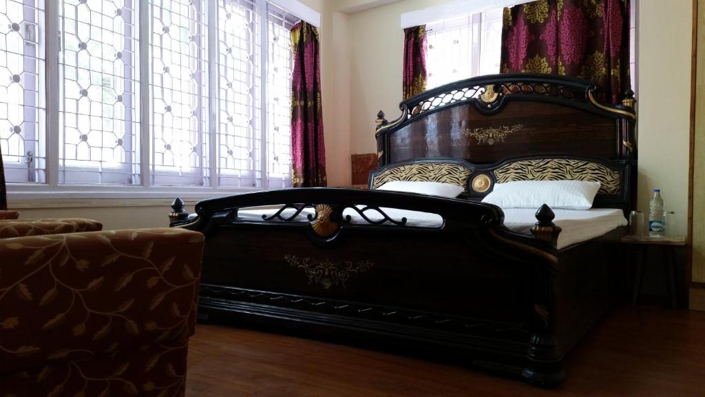 a bed in a room with a large window at Flyer Exotica in Shimla