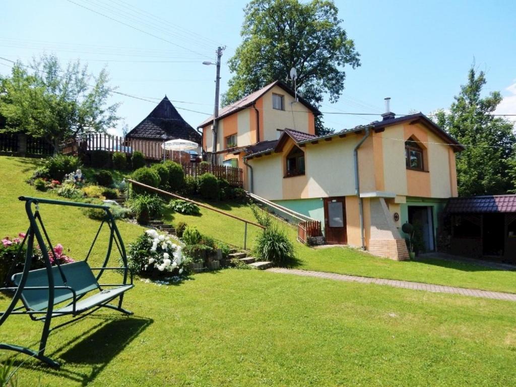 a yard with a swing in front of a house at Penzión Bajo in Dolný Kubín