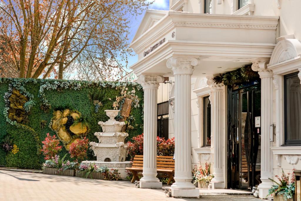 a white building with a bench in front of it at Grand Sapphire Hotel & Banqueting in Croydon