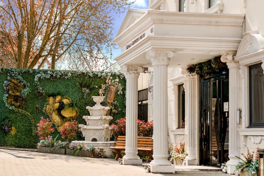 un edificio blanco con un banco delante en Grand Sapphire Hotel & Banqueting, en Croydon