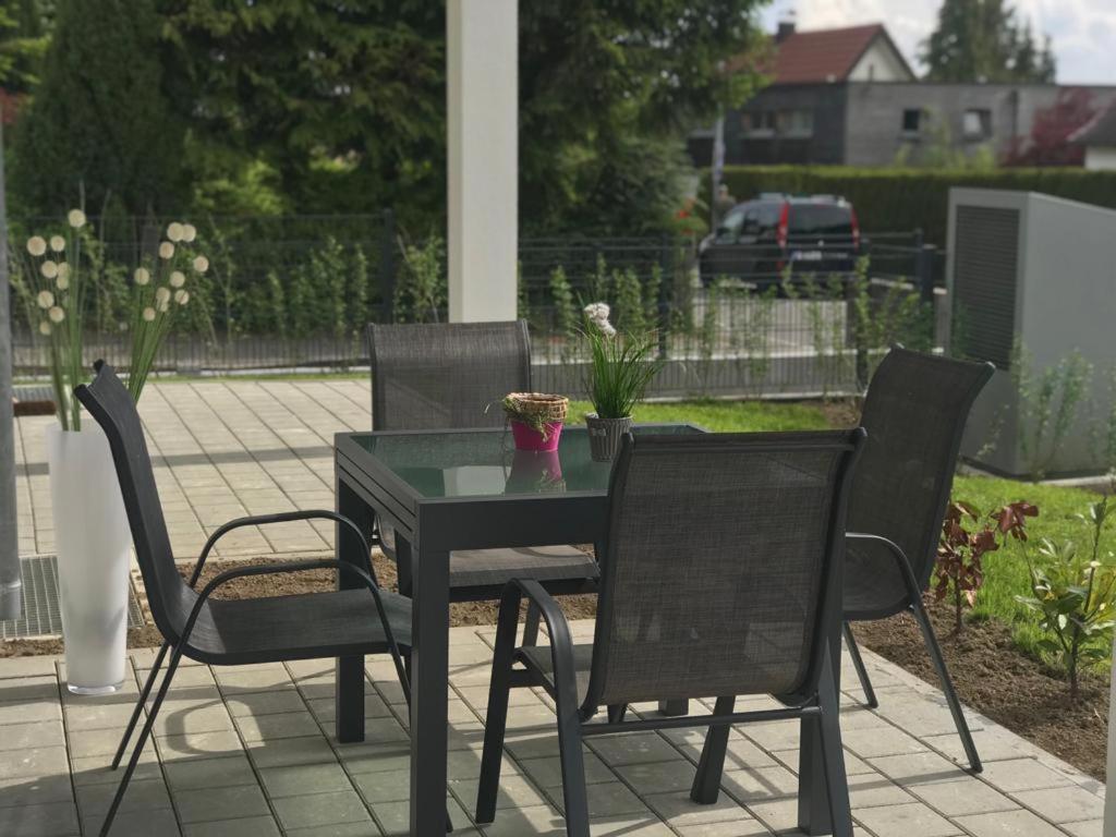 a table with two chairs and a table with flowers on it at Ferienwohnung am Strandbad in Friedrichshafen