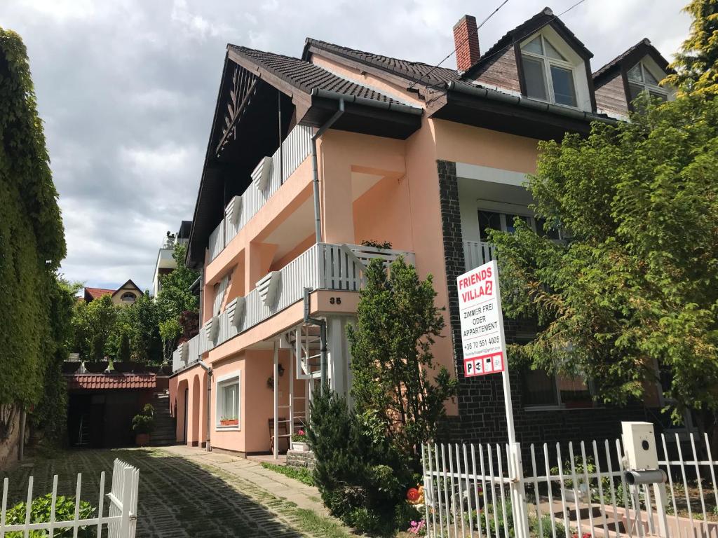 uma casa cor-de-rosa sem sinal de estacionamento em frente em Friends Villa Apartments 2 em Hévíz