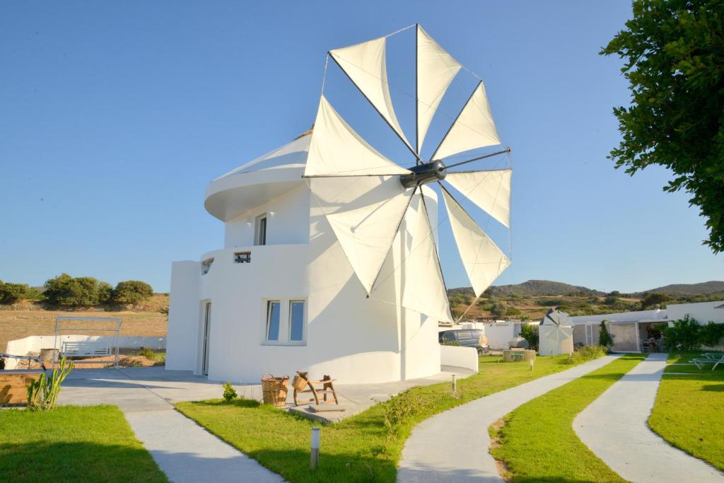 um grande moinho de vento ao lado de um edifício branco em villa windmill em Zefiría