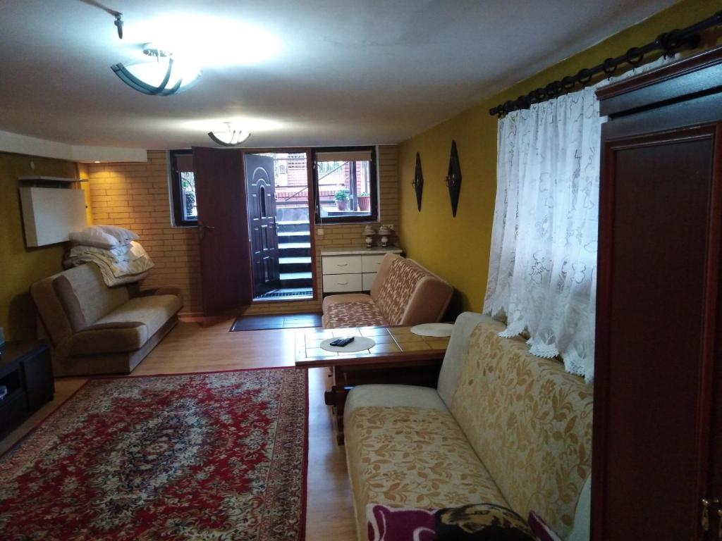 un soggiorno con divano e tavolo di POKÓJ MERY a Augustów