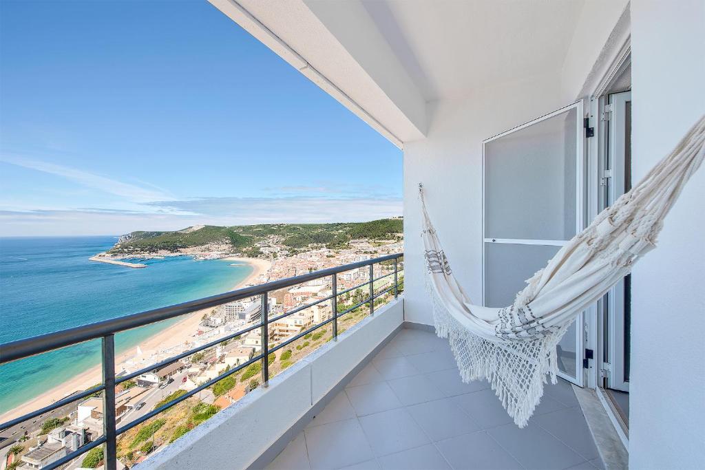 a balcony with a hammock and a view of the beach at Casa do Mar in Sesimbra