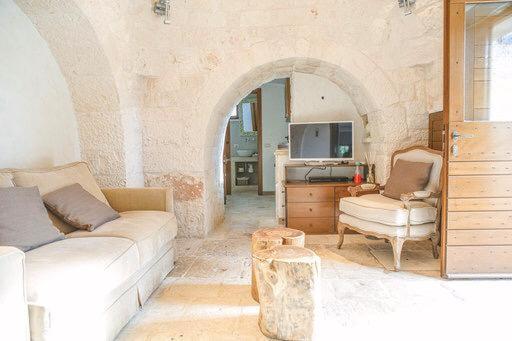 salon z 2 kanapami i łukiem w obiekcie Trullo Grace -Trulli Anti' Charme & Relax w Alberobello