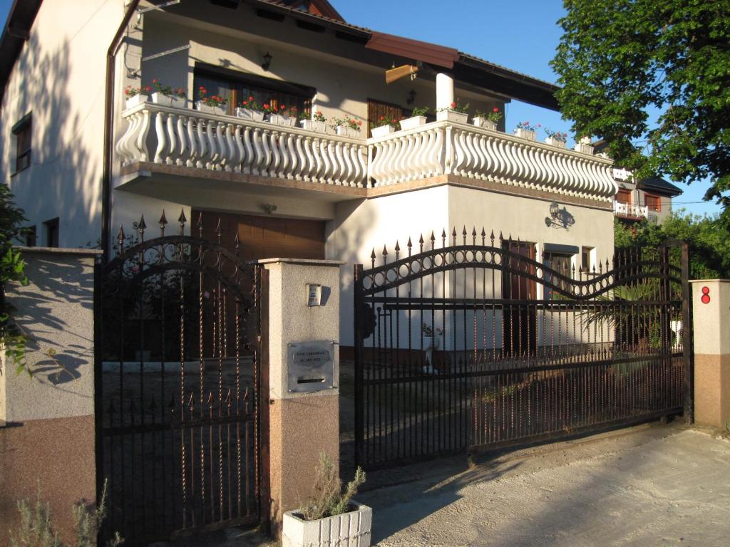 Casa blanca con puerta y balcón en Room Yasica 2, en Izačić