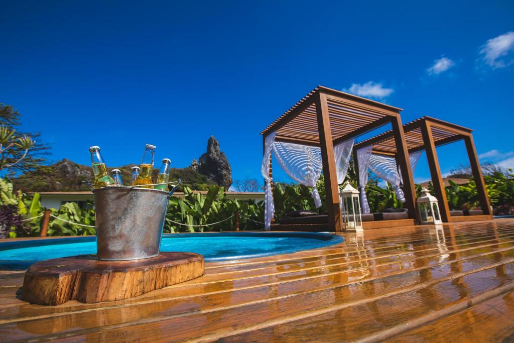 a bucket of wine bottles on a deck next to a pool at Dolphin Hotel in Fernando de Noronha