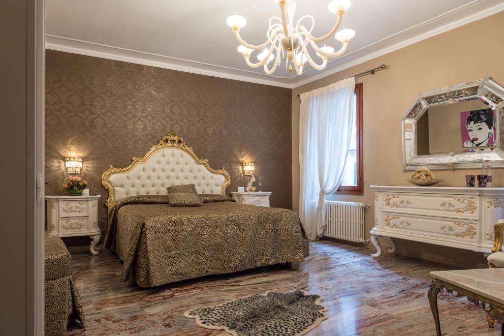 a bedroom with a bed and a mirror and a chandelier at Ca' del Cinema B&B in Venice