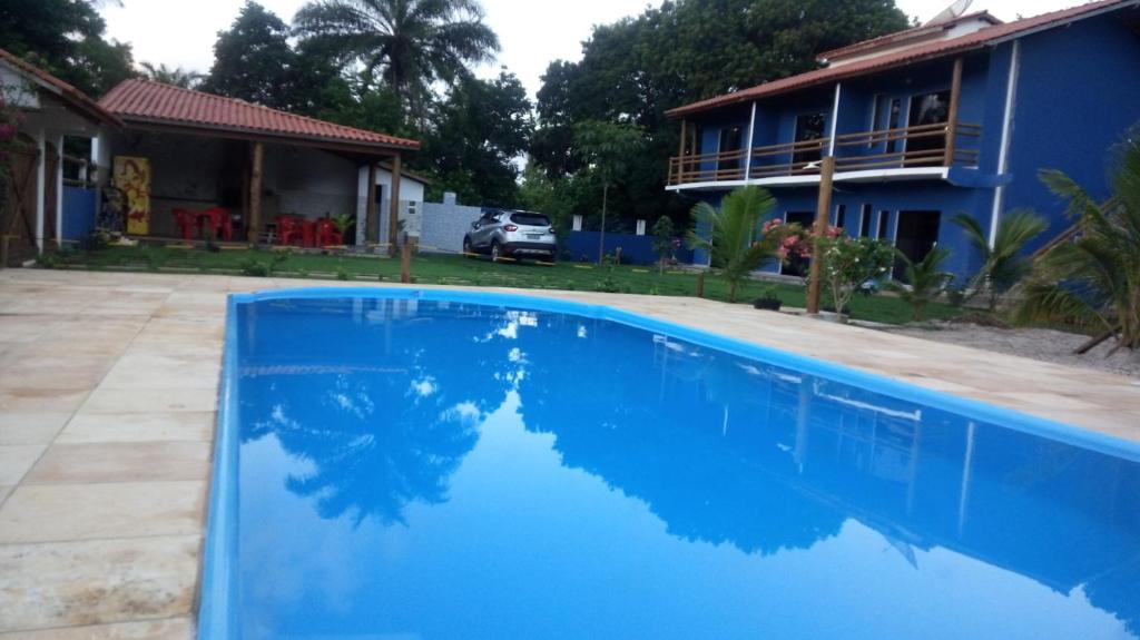 a blue swimming pool in front of a house at Recanto Calua in Serra Grande