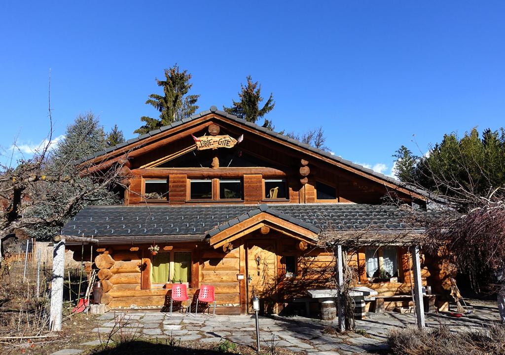 a log cabin with red chairs in front of it at Le Gite de Briey in Chalais