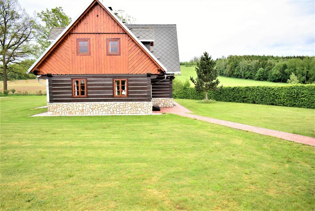 a house with an orange roof on a green yard at Villa Harta II MAGDA in Vrchlabí