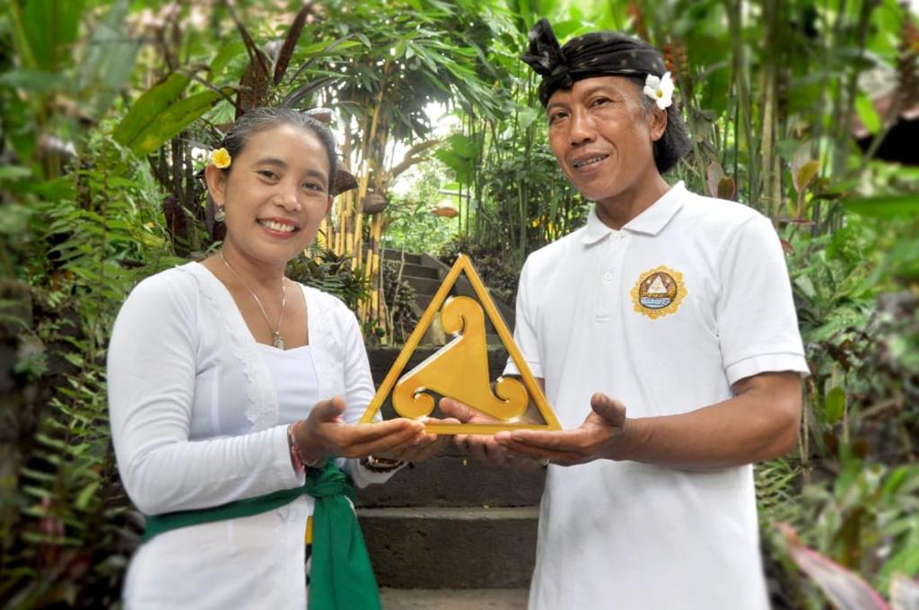 a man and a woman holding up a sign at Pondok Masa Depan in Sidemen
