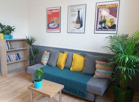 a living room with a blue couch with yellow pillows at Appt 2ème étage sur l’ile de Saumur in Saumur