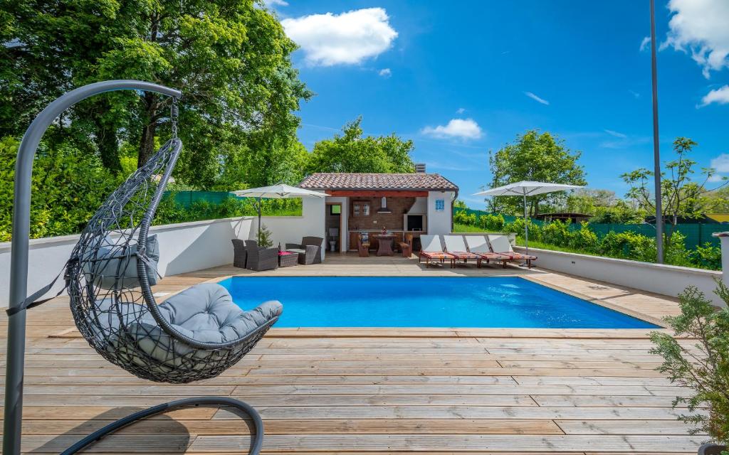 a hammock by a swimming pool with a house at House Smoky with private pool and jacuzzi in Pazin