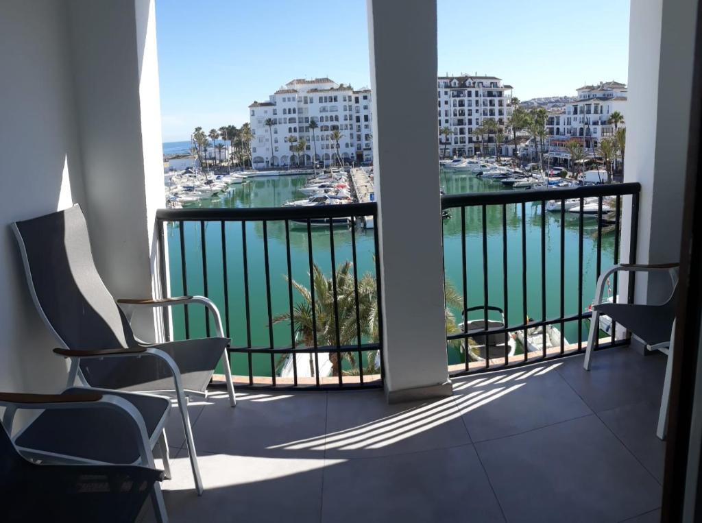 einen Balkon mit Stühlen und Blick auf das Wasser in der Unterkunft Duquesa Seafront Marina in Manilva