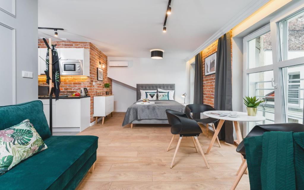 een woonkamer met een bed, een bank en een tafel bij Barbakan Residence Old Town in Krakau