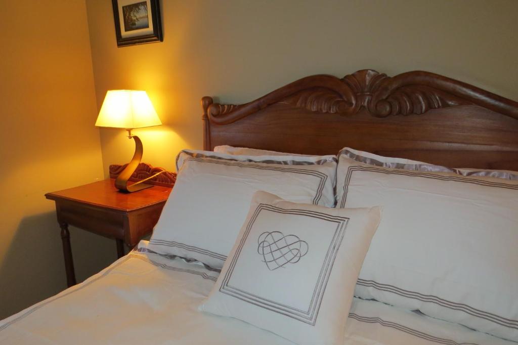 a bed with two pillows with a heart on it at Appart-hôtel Villégiature Saint-Sauveur in Piedmont