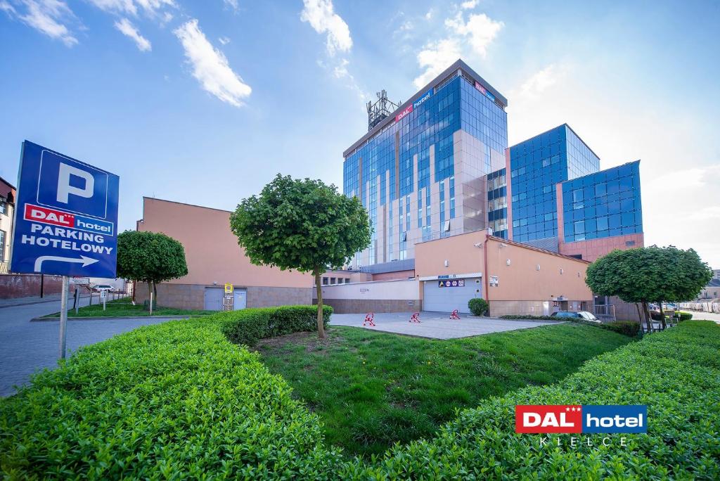 Modern DAL hotel building with parking sign and manicured green lawn under blue sky