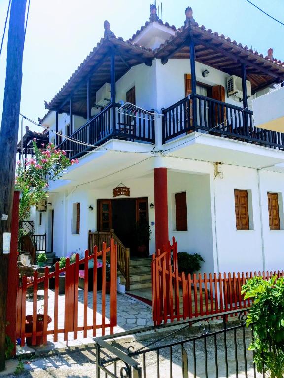 a white house with a red fence in front of it at Dafni Studios in Neo Klima