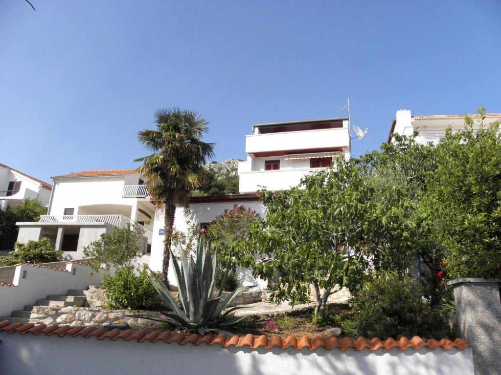 a white building with trees in front of it at Apartments Marija - 30m from the beach in Murter