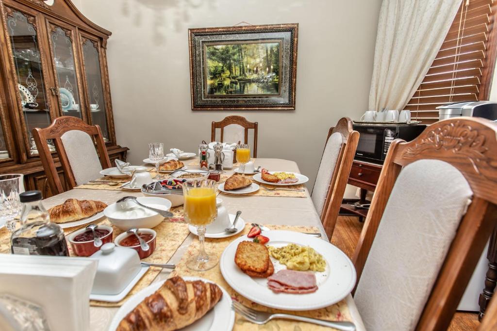 a dining table with food and drinks on it at Ambiance By The Falls B&B in Niagara Falls