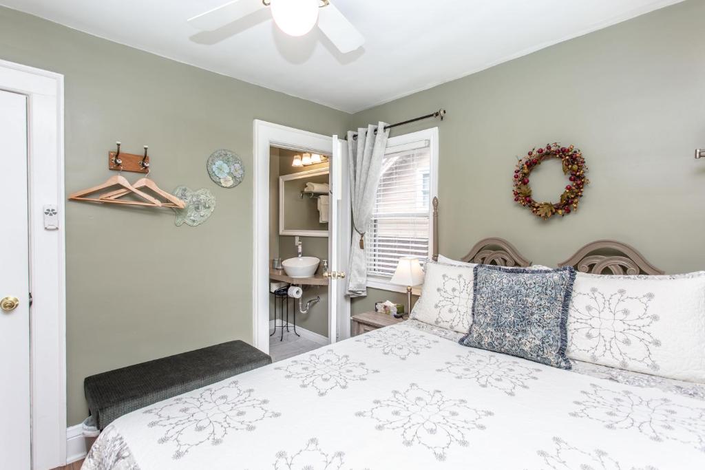 a bedroom with a white bed with a wreath on the wall at Ambiance By The Falls B&B in Niagara Falls