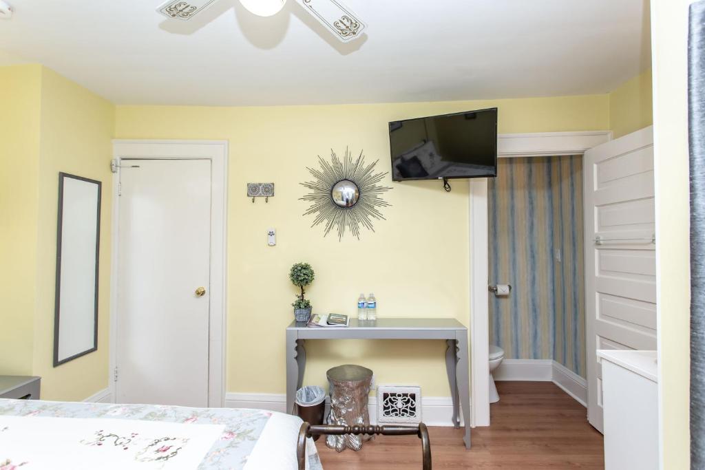 a bedroom with a bed and a tv on the wall at Ambiance By The Falls B&B in Niagara Falls
