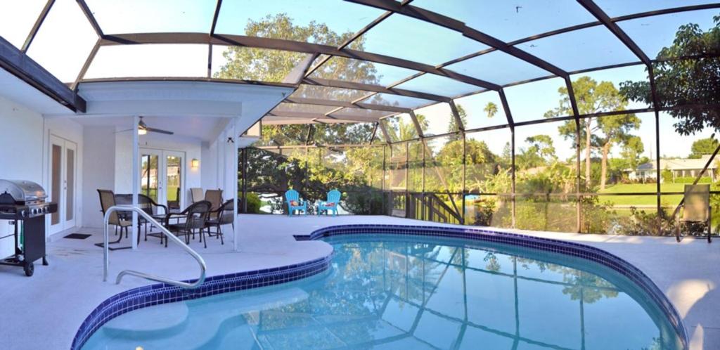 a swimming pool in a house with a glass ceiling at Bradenton Lakefront Home 1903 in Bradenton