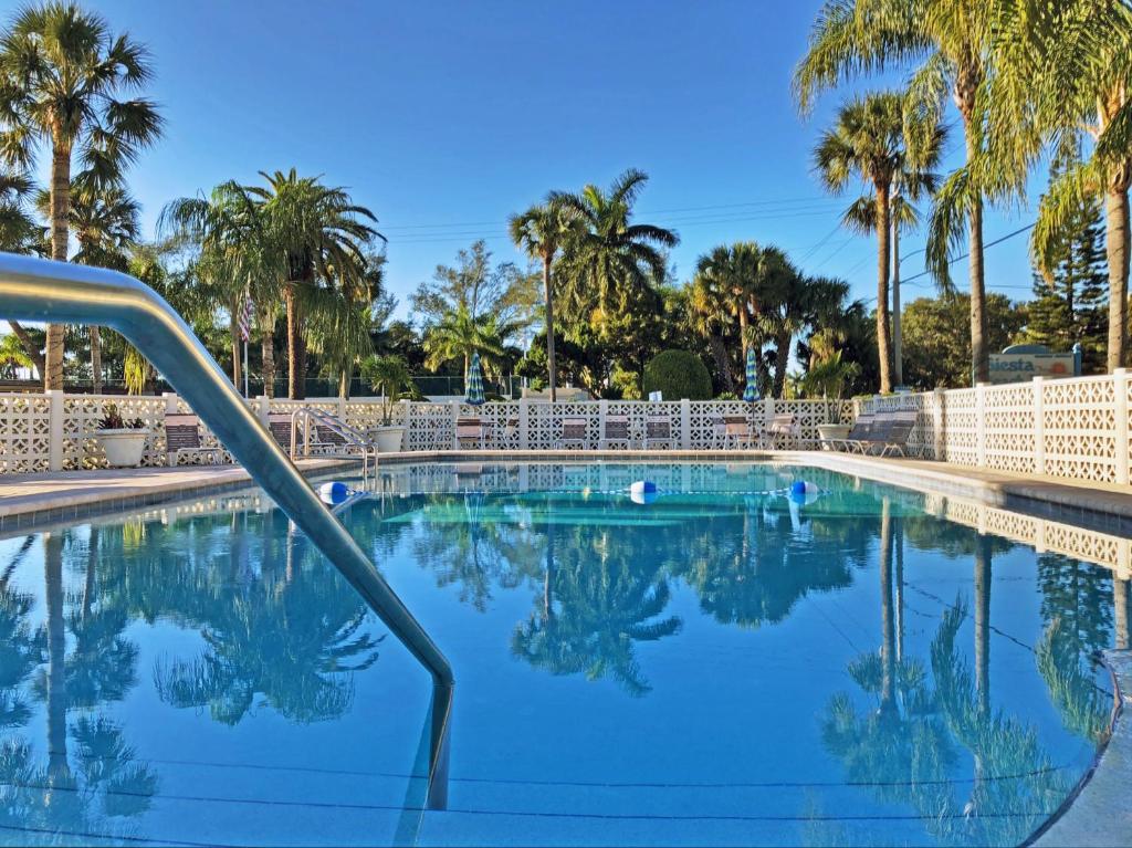 a swimming pool with palm trees in the background at Siesta Key Beach 5950 #317 in Sarasota