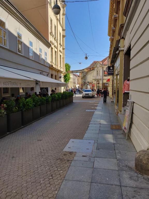 an empty city street with buildings and a sidewalk at Metropolis Apartments in Zagreb