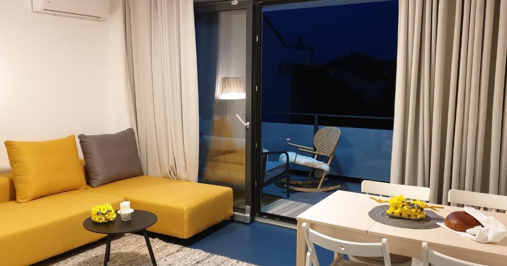 sala de estar con sofá amarillo y mesa en Genius Guest Unique Banovci Apartment, en Banovci