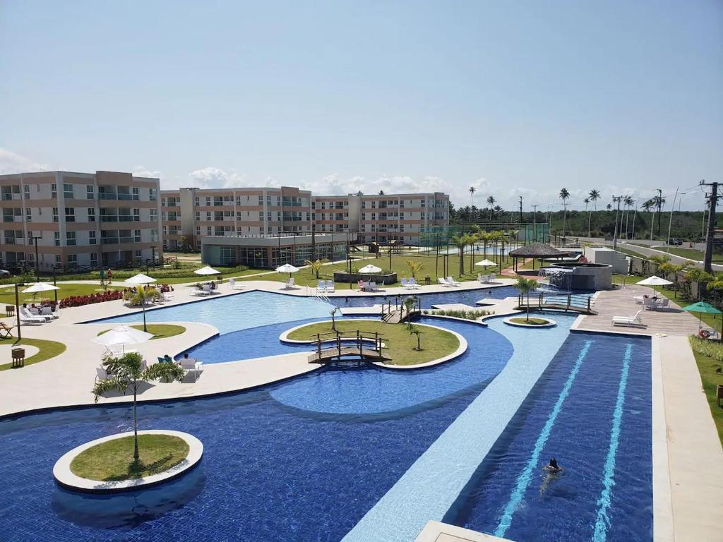 una grande piscina con acqua blu in un resort di Muro Alto Condomínio Clube a Porto De Galinhas