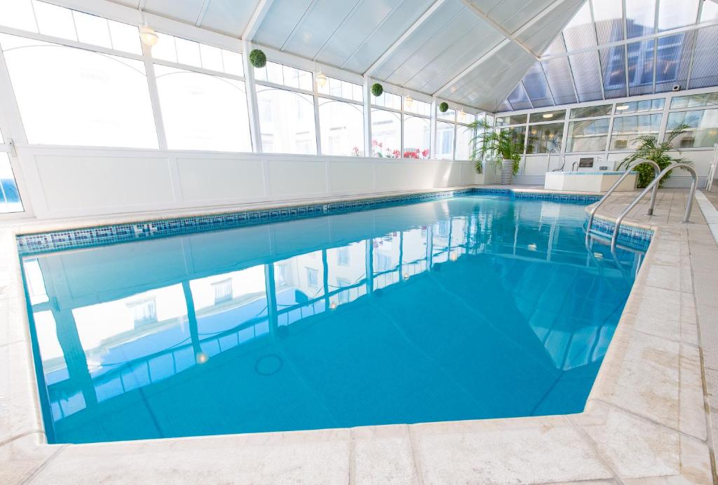 a large swimming pool with blue water in a building at The Monterey Hotel - Sure Hotel Collection by Best Western in Saint Helier Jersey