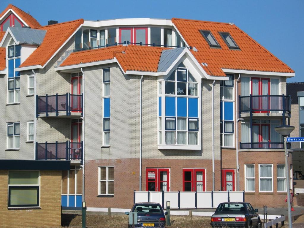 un immeuble d'appartements avec un toit orange dans l'établissement Penthouse Belle Vue, à Bergen aan Zee