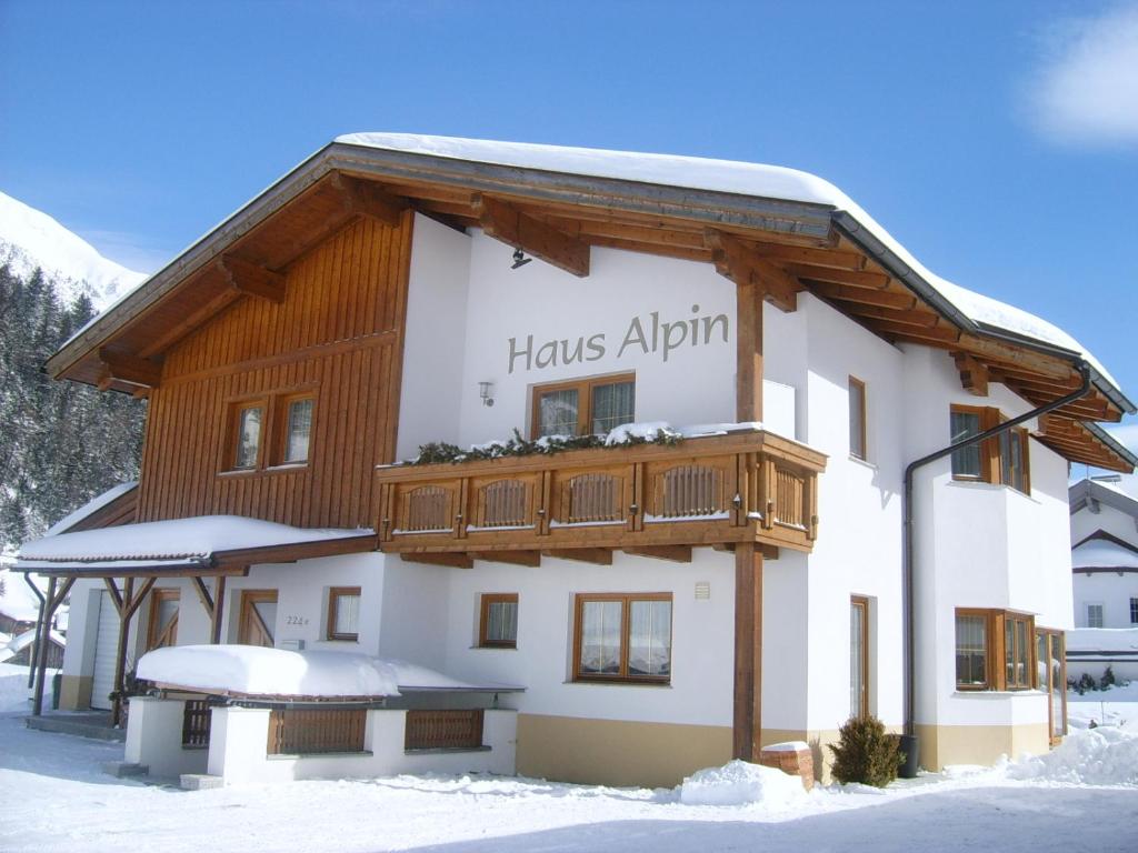 ein Gebäude mit einem Schild, auf dem die Hütten Alpha stehen in der Unterkunft Haus Alpin Apartments in Pettneu am Arlberg