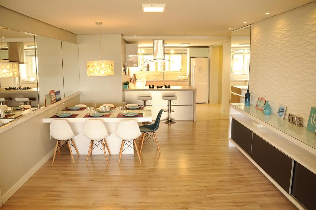 - une cuisine avec une table et des chaises dans la chambre dans l'établissement Apto Novo e Moderno no Centro de Gramado, à Gramado