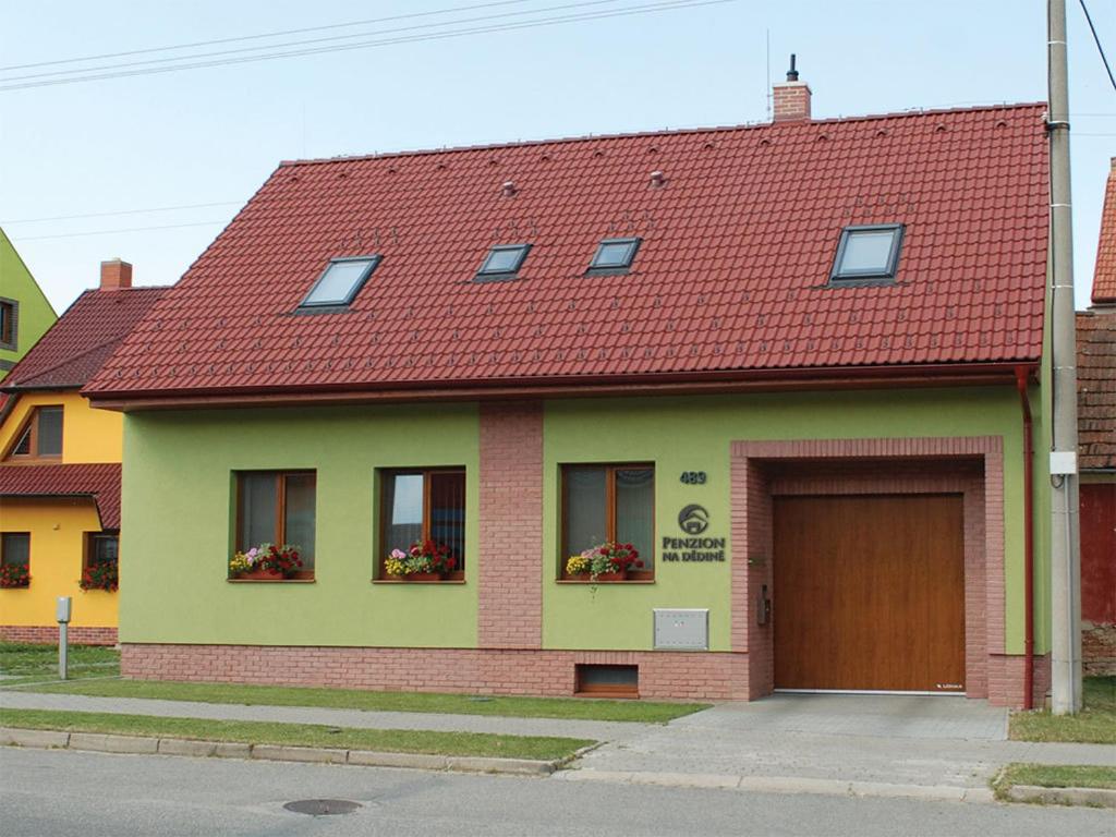 une maison avec un toit rouge et un garage dans l'établissement Penzion Na Dědině, à Mutěnice