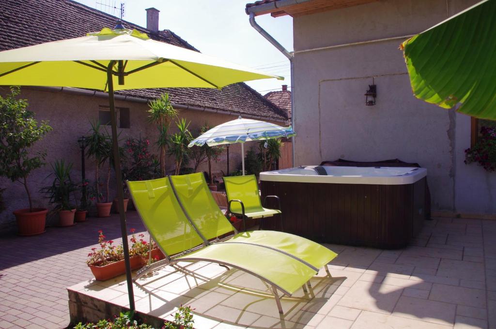 a pair of chairs and an umbrella next to a bath tub at Tölgyfakuckó apartman in Baja