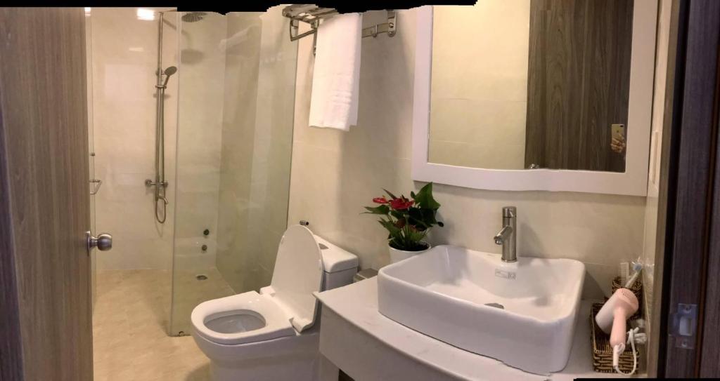 uma casa de banho com um WC, um lavatório e um chuveiro em DẠ LAN HOTEL em Da Lat