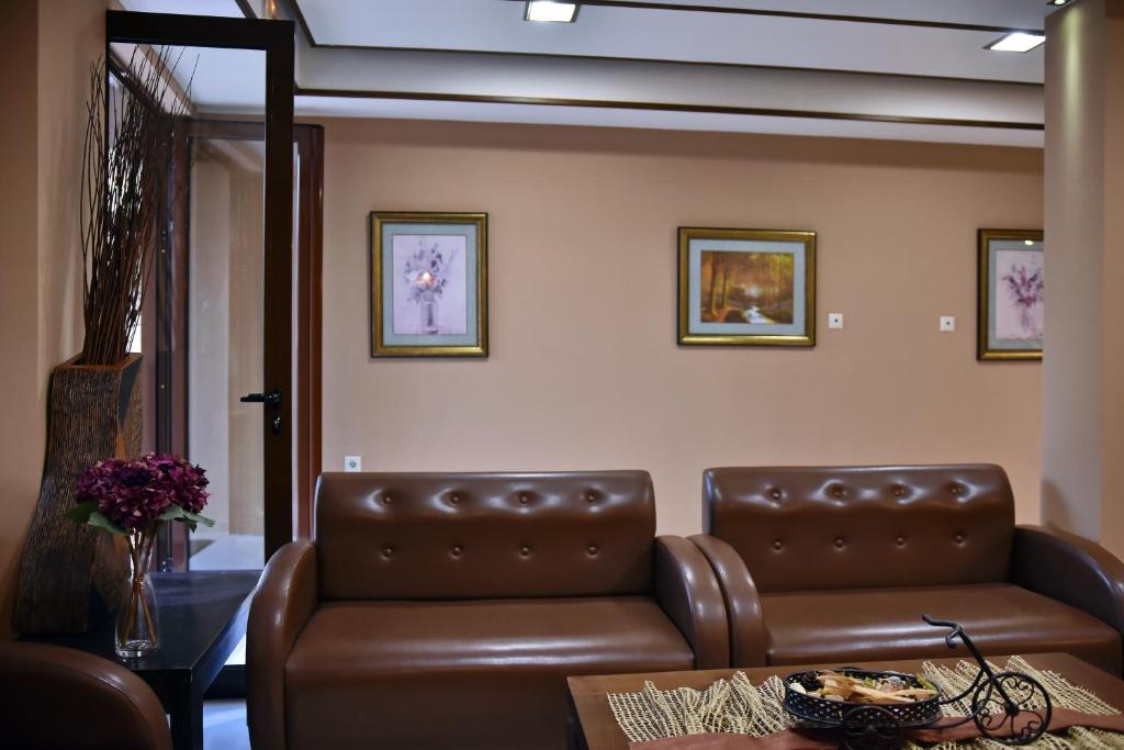 a waiting room with a leather couch and a table at 24 Seven Boutique Hotel in Malia
