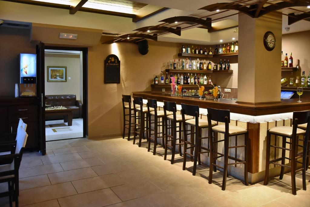a bar in a restaurant with stools at 24 Seven Boutique Hotel in Malia