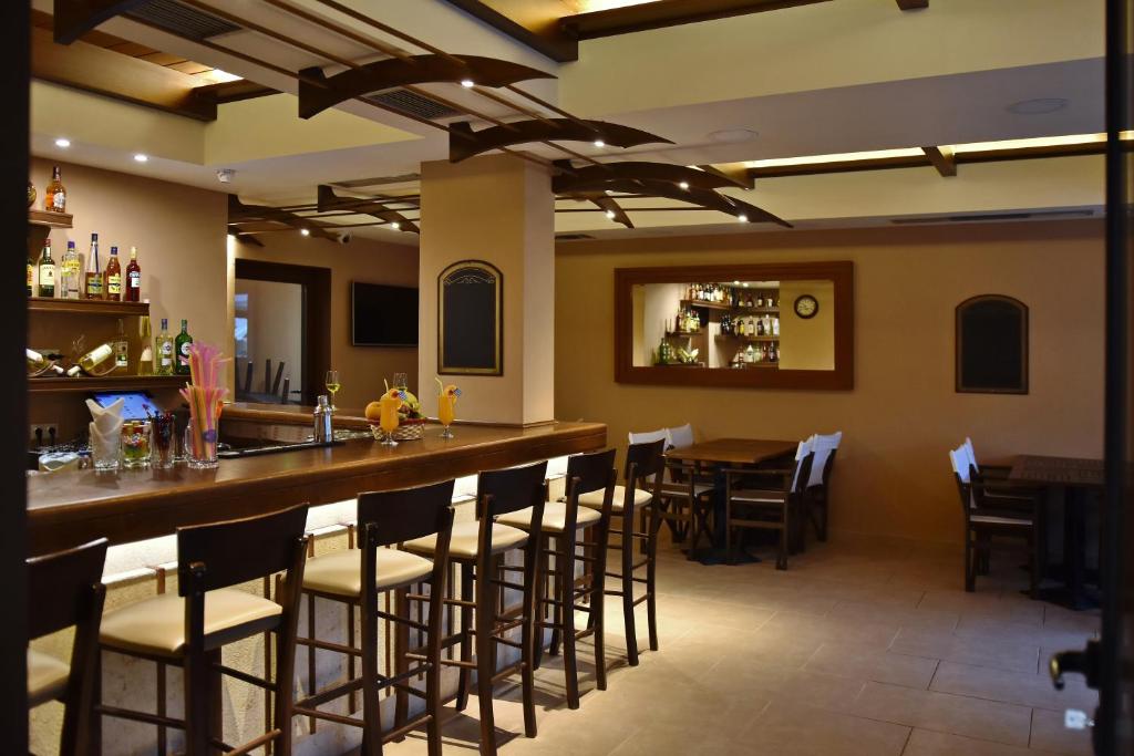 a bar in a restaurant with a table and chairs at 24 Seven Boutique Hotel in Malia