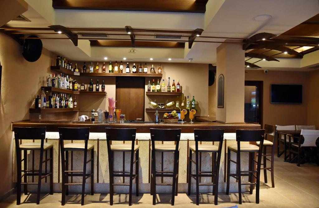 a bar with bar stools in a restaurant at 24 Seven Boutique Hotel in Malia