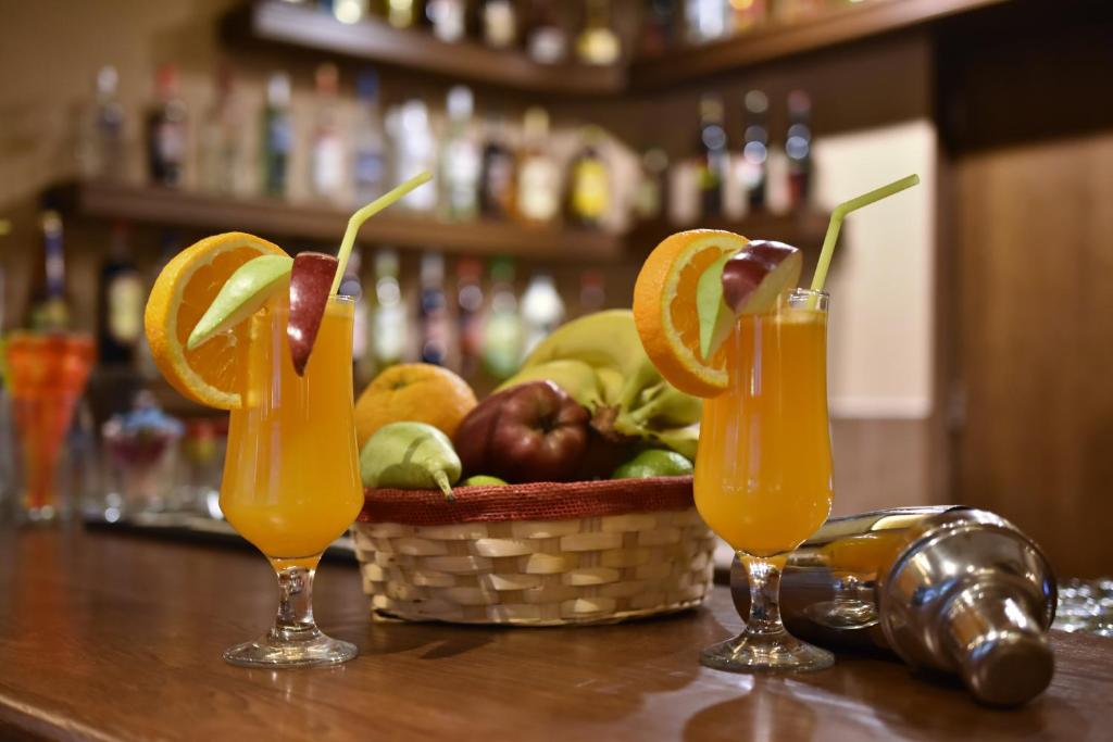two glasses of orange juice and a basket of fruit at 24 Seven Boutique Hotel in Malia
