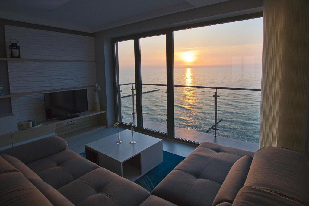 a living room with a couch and a view of the ocean at Apartamenty Na Klifie in Ustronie Morskie