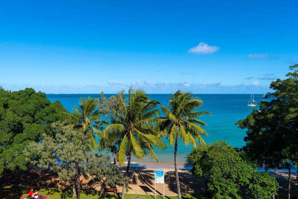 a view of a beach with palm trees and the ocean at Hotel Beaurivage in Noumea