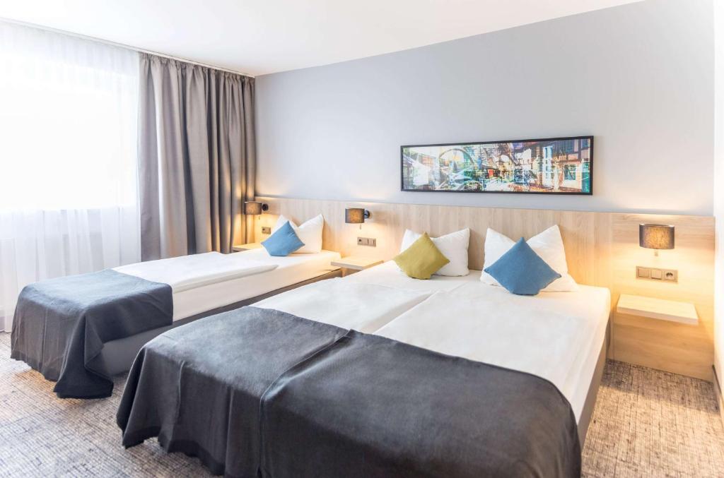 Postel nebo postele na pokoji v ubytování Ramada by Wyndham Flensburg City