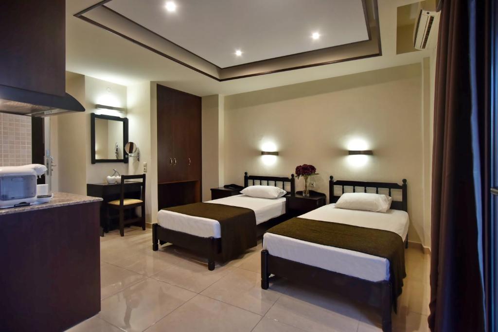 a hotel room with two beds and a kitchen at 24 Seven Boutique Hotel in Malia