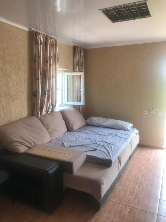 ヴィチャゼヴォにあるНомера у моряのソファと窓が備わるドミトリールームのベッド1台分です。